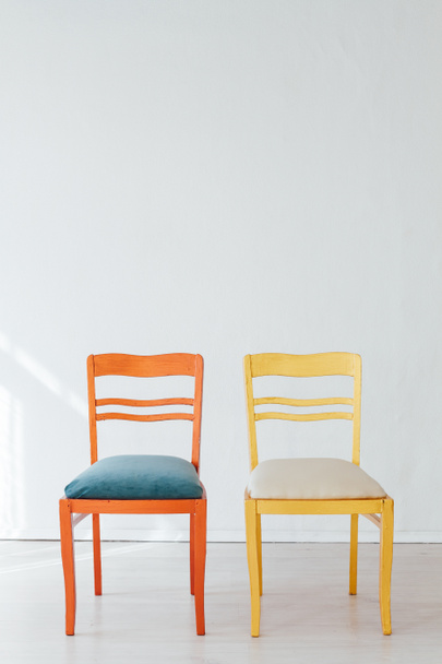 sillas multicolores en el interior de una habitación blanca vacía
 - Foto, imagen