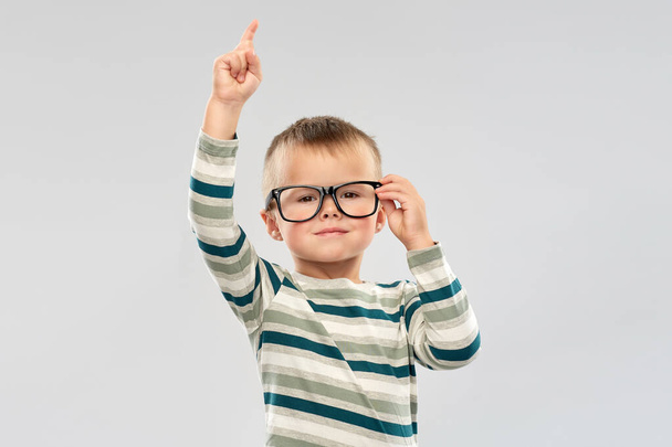 portrait of boy in glasses pointing finger up - Foto, Imagem
