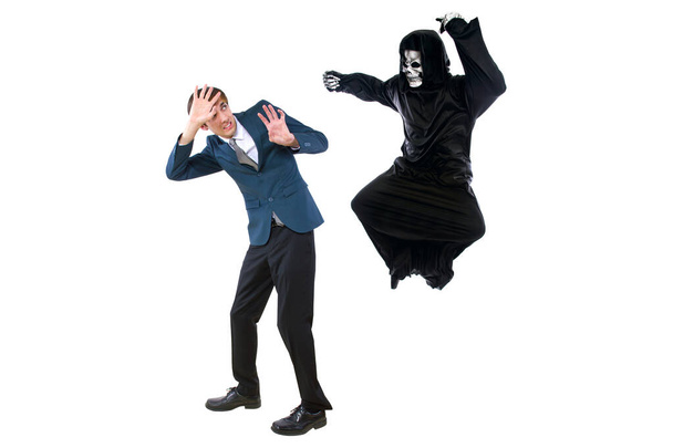 Man in a Halloween grim reaper ghost costume chasing, mocking and making fun of scared businessman running away.  Can also depict death following a man as a metaphor for life insurance.  - Fotó, kép
