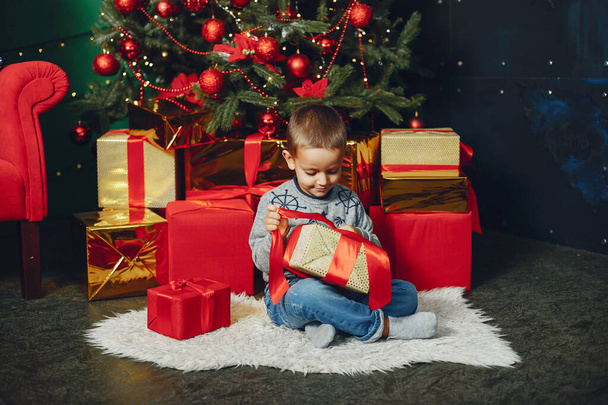 Little boy sitting near christmas tree - Valokuva, kuva