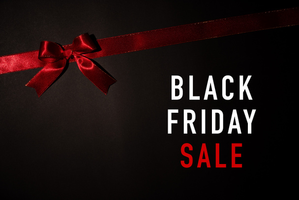 Top view of red ribbon on black background with copy space for text. black Friday and Boxing Day composition. - 写真・画像