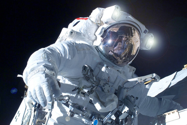 Astronaut in a spacesuit in open space. Elements of this image were furnished by NASA. - Photo, Image