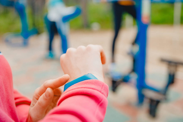 Ragazza sport utilizza il dito tocca braccialetto fitness per misurare la frequenza cardiaca e il numero di passi, tecnologia utile
 - Foto, immagini