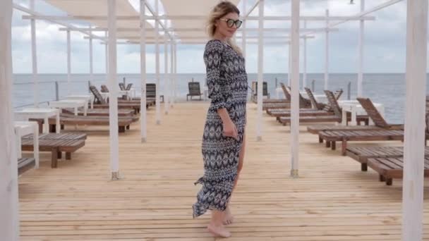 Krásná žena jde bosá podél mola, Breezes oblečení ženy na břehu oceánu, Relax of girl - Záběry, video