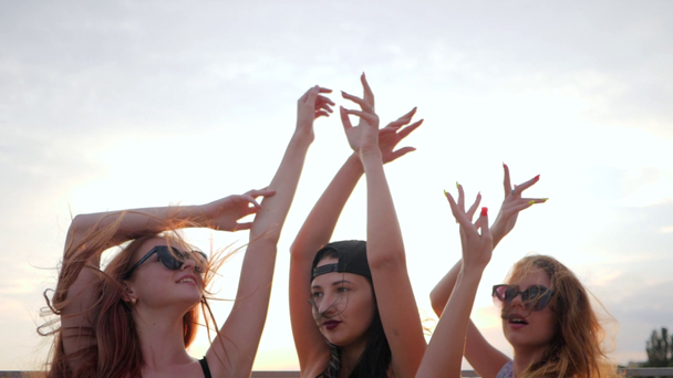 close up faces girlfriends, summer evening, happy best friends dancing in sunset on beach, three female raises arms - Video, Çekim