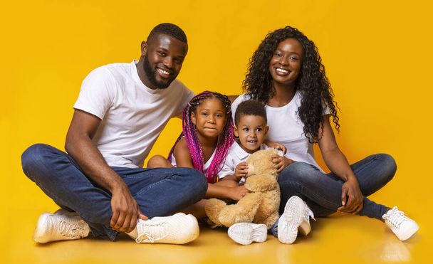 Afro famille avec fille et fils assis ensemble sur le sol
 - Photo, image