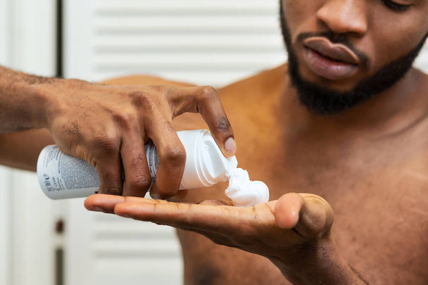 African american man putting shaving foam on palm - Фото, зображення