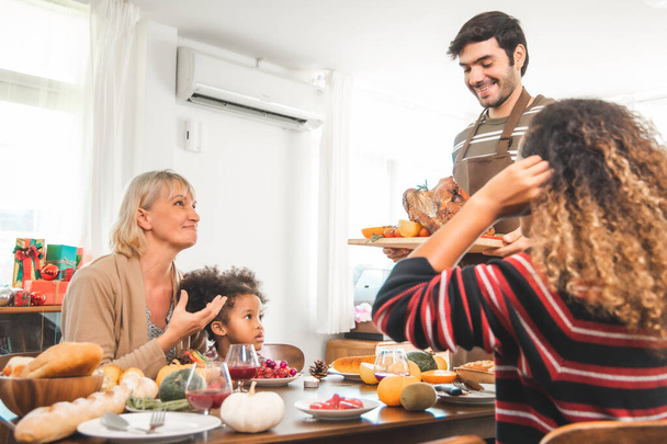 Thanksgiving Celebration Tradition Family Dinner Concept.family having holiday dinner and cutting turkey.Young black adult woman and her daughter happy. - Φωτογραφία, εικόνα