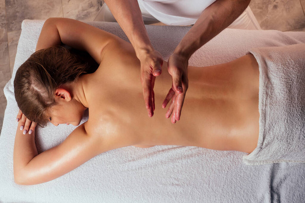 Young woman enjoys ayurvedic facial massage in luxury resort - Photo, Image
