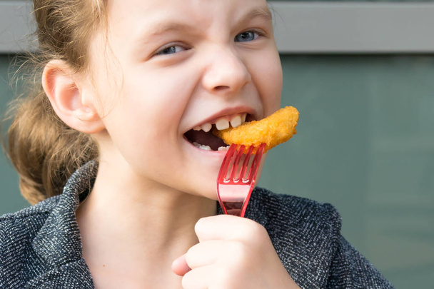 girl eating shrimp in batter, front view, close-up - Photo, image