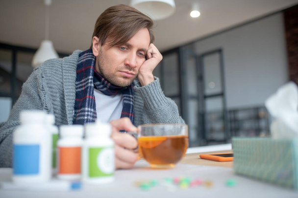 Man feeling lonely and bored while having flu - 写真・画像
