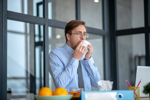 Businessman sneezing all day at work and feeling dizzy - Fotoğraf, Görsel