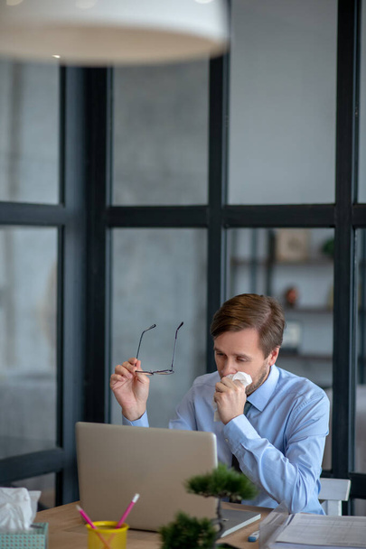 Businessman taking glasses off while sneezing all day - Фото, зображення