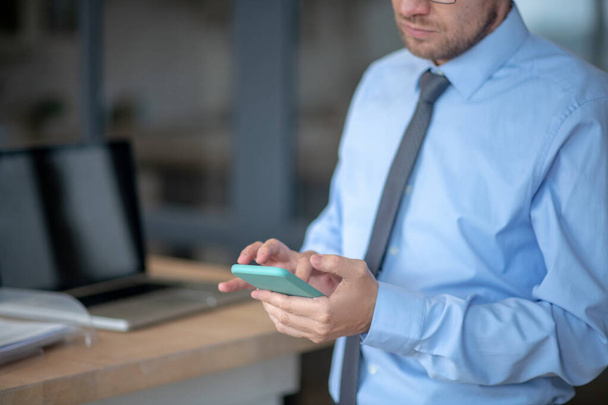 Businessman wearing shirt and tie using smartphone - Fotó, kép