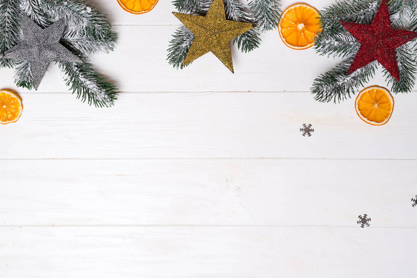 Karácsonyi üdvözlőlap dekorációval és fenyőággal fehér fából készült háttérrel. Top nézet másolási hely az üdvözletét - Fotó, kép