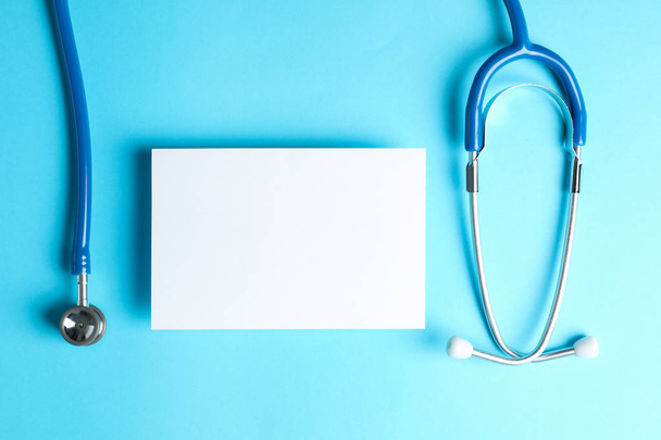 Stethoscope and notepad on a blue background, space for text - Foto, Imagem