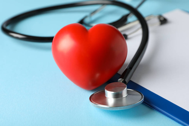 Stethoscope and red heart on blue background, close up. Healthca - Φωτογραφία, εικόνα