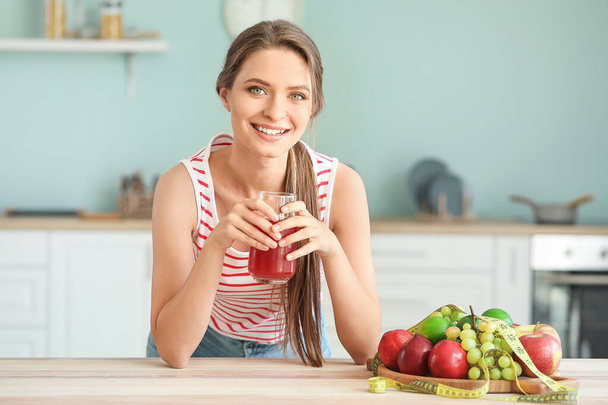 若い女性は台所で健康なジュースを飲む。国会の概念 - 写真・画像