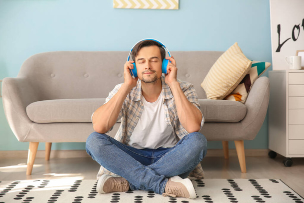 Komea mies kuuntelemassa musiikkia kotona
 - Valokuva, kuva