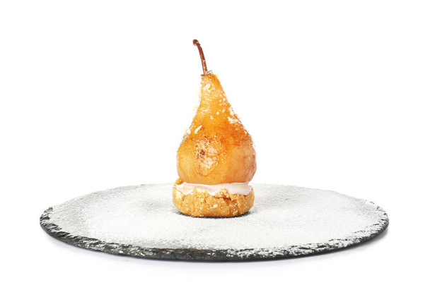 Slate plate with tasty cooked pear on white background - Фото, зображення