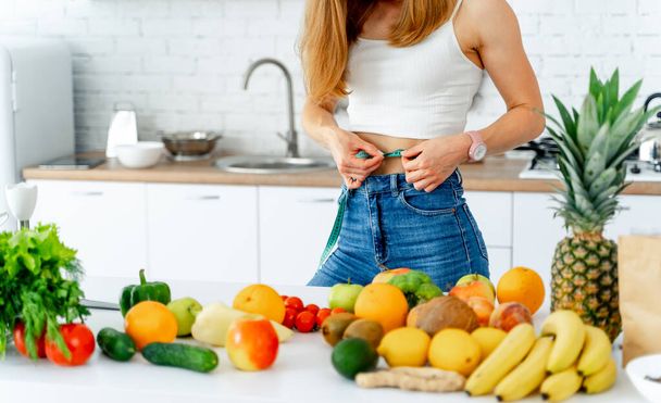 Dieting concept .Diet. Beautiful Young Woman near in the kitchen with healthy food. Fruits and Vegetables. - 写真・画像