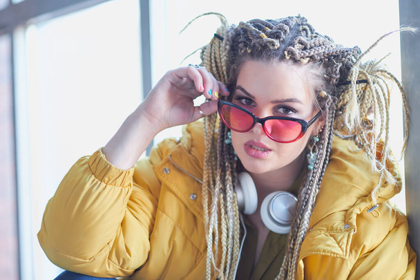 Porträt einer exzentrischen modernen Frau, helle Make-up-Sonnenbrille und verrückte Frisur. großspurige Teenager-Millennials - Foto, Bild