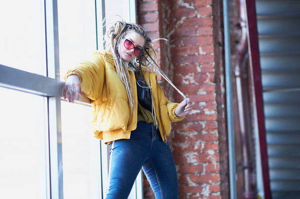 portrait of an eccentric modern young woman, bright make-up sunglasses, and a crazy hairstyle. cocky teen millennial - 写真・画像