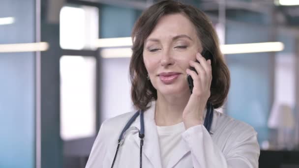 Portrait of Professional Middle Aged Doctor Smiling and Talking on Smart Phone - Felvétel, videó