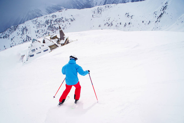 Photo from back sports man skiing on snowy slope. - Foto, immagini