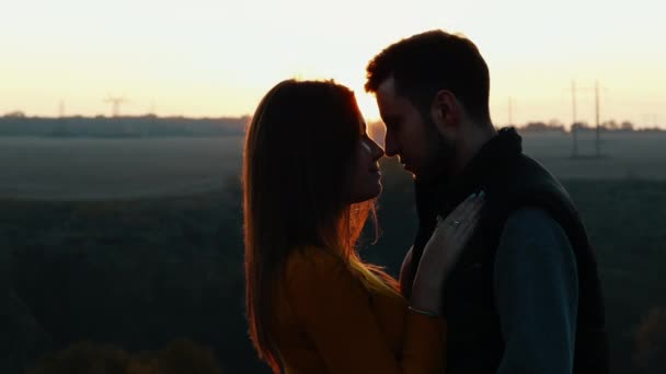 Frst czule całuje uroczą młodą parę o zachodzie słońca - Materiał filmowy, wideo