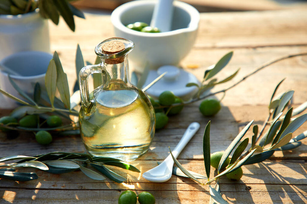 jug with olive oil and green olives on table - Foto, Imagem