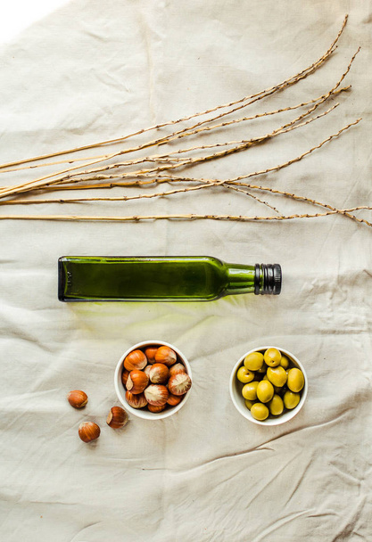 Extra virgin Walnut oil in a green glass bottle and green olives - Valokuva, kuva