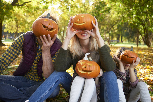Rodzina trzyma Halloween dynie przed ich twarzy  - Zdjęcie, obraz