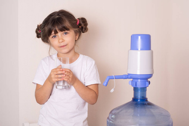 Dzieciak pijący wodę z pompy ręcznej nacisnąć pompę ręczną wody. Dostawa wody w domu koncepcja. - Zdjęcie, obraz