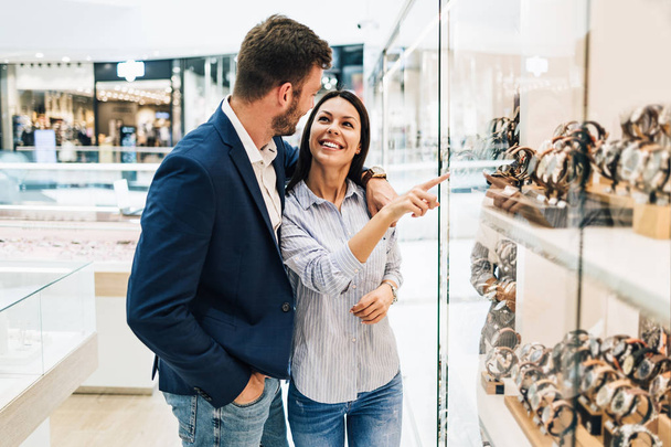 Beautiful couple enjoying in shopping at modern jewelry store.  - Photo, Image