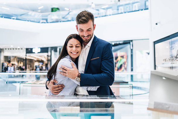 Beautiful couple enjoying in shopping at modern jewelry store.  - Zdjęcie, obraz