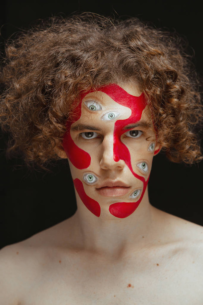 Man studio portrait with makeup for halloween. Abstraction on the face and many eyes. - Fotografie, Obrázek