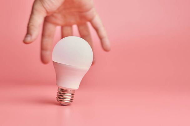 Light bulb and hand, idea catching concept. Symbol of new events or finding solutions to problems. Creative minimal innovations. - Foto, immagini