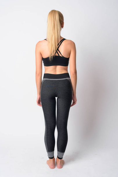 Full body shot rear view of young blonde woman ready for gym - Photo, Image