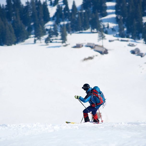 Skier πεζοπόρος με σακίδιο στα σκι σε βαθύ λευκό χιόνι στο φόντο του όμορφου χειμερινού τοπίου - Φωτογραφία, εικόνα