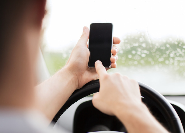 Man using phone while driving the car - 写真・画像