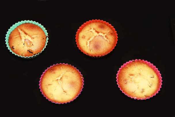 печені печиво кекси з родзинками в різнокольорових силіконових формах
 - Фото, зображення