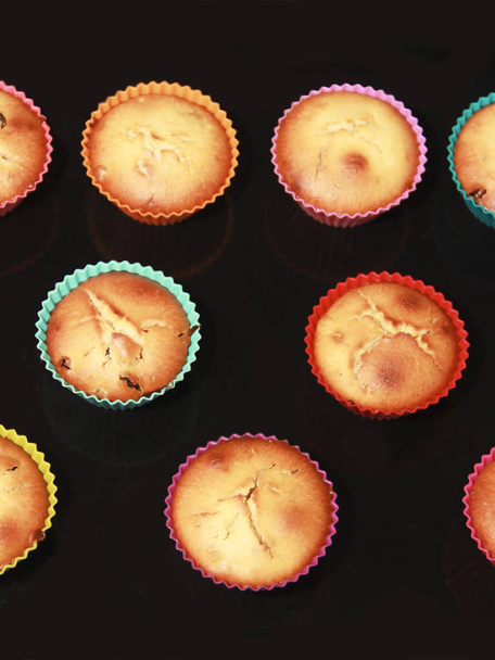muffins de biscuits cuits cuits avec des raisins secs dans des moules en silicone multicolores
 - Photo, image