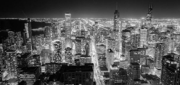 Filtrelenmiş siyah beyaz görüntü hava görüntüsü alacakaranlıkta Chicago şehir merkezindeki gökdelenleri aydınlattı - Fotoğraf, Görsel