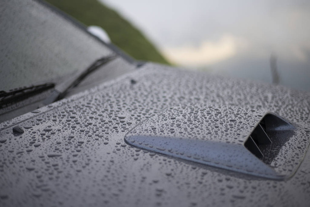 Σταγόνες βροχής που προσκολλώνται στο γυαλί και το σώμα του αυτοκινήτου, Κοντινό πλάνο - Φωτογραφία, εικόνα