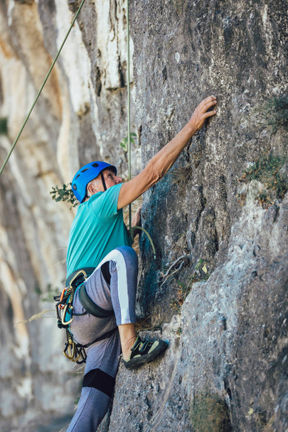 Uomo anziano con una corda arrampicata sulla roccia
. - Foto, immagini