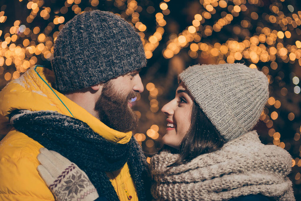 Profile photo of two people guy lady kissing outside lights midnight park newyear evening stand opposite snowy weather wear winter coats scarfs hats outdoors - Foto, imagen