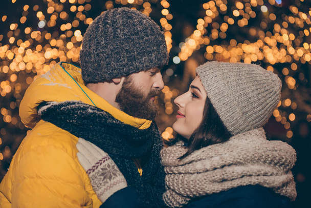 Profile photo of two people couple guy lady kissing outside illuminated midnight park x-mas evening stand opposite magic moment wear winter coats scarfs hats outdoors - Фото, изображение
