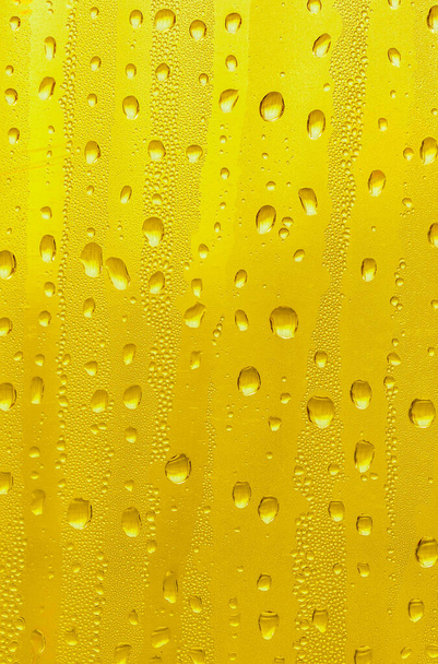 Σταγόνες νερού στο γυαλί, κίτρινη μπίρα υποβάθρου, φόντο. - Φωτογραφία, εικόνα