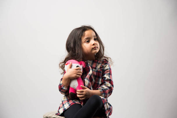 Beyaz arka planda izole edilmiş, yumuşak oyuncaklarla oynayan Hintli küçük kız. - Fotoğraf, Görsel